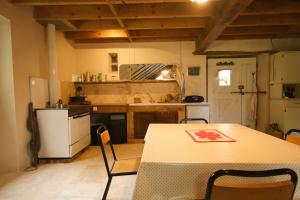 a kitchen with a table and a table and chairs at Le Refuge de Bruno in Saint-Amans-Soult