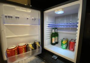 een open koelkast met drankjes en blikjes frisdrank bij Wanda Jin Pingxiang in Pingxiang