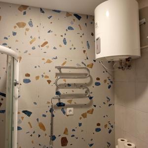 a bathroom with a wall covered in broken tiles at VilniusCentralSpot in Vilnius +7 photos