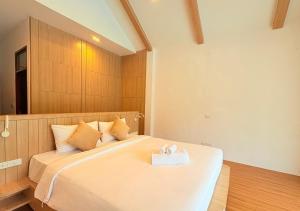 Un dormitorio con una cama con una toalla encima. en The Poom Cafe & Resort Khao Yai, en Ban Khanong Phra Klang (1)