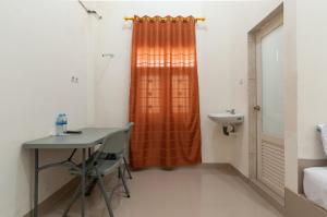 een badkamer met een tafel, een wastafel en een douche bij RedDoorz near UISU teladan Medan in Medan +16 foto's