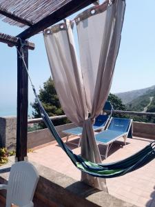 una hamaca y 2 sillas en un patio en Appartamenti Salato, en Tropea