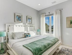 een witte slaapkamer met een groot bed en een raam bij Ocean View Modern in Tybee Island +43 foto's