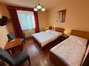 a hotel room with two beds and a chair at Penzion U Golema Blansko in Blansko