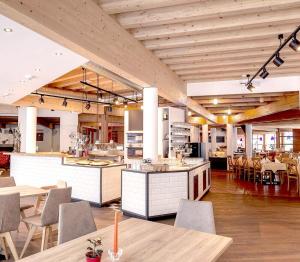 a large kitchen and dining room with tables and chairs at Gut Wenghof - Family Resort Werfenweng in Werfenweng