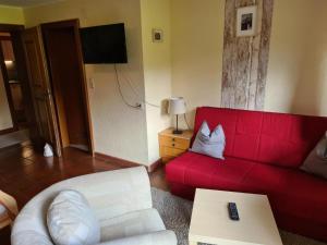 a living room with a red couch and a table at Appartement Sonnenspitze 5 in Ehrwald