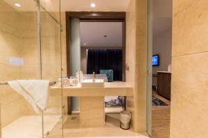 une salle de bain avec lavabo et douche dans l'établissement Hotel Lumbini Heritage, à Rummindei