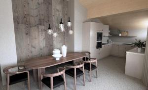 a kitchen with a wooden table and two chairs at fuchs am meer in Mitterhofen