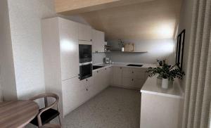 a kitchen with white cabinets and a table and a table and a table at fuchs am meer in Mitterhofen