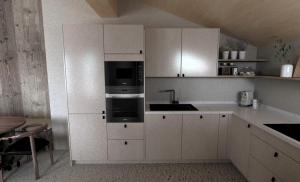 a white kitchen with a sink and a microwave at fuchs am meer in Mitterhofen