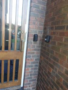 a brick wall with a wooden door in front at 48 Harper Road Beckton Shared in East Ham