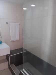 een badkamer met een glazen douche en een wastafel bij Vila Verde House in Santa Maria