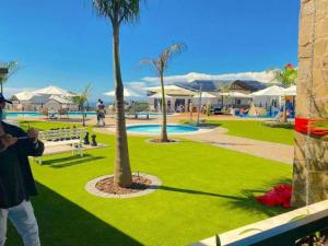 a man taking a picture of a park with palm trees at Ballito Hills Lifestyle Estate in Ballito