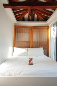 a bedroom with a white bed with a wooden headboard at 무료주차 스파 청량리 가족 독채 한옥 in Seoul +79 photos