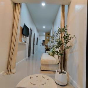a hallway with a couch and a potted plant at Baanjaifu บ้านใจฟู in Mukdahan +14 photos
