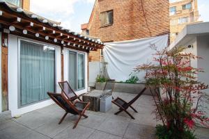 a patio with two chairs and a heater on a balcony at 무료주차 스파 청량리 가족 독채 한옥 in Seoul