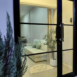 a living room with a couch and a mirror at Baanjaifu บ้านใจฟู in Mukdahan