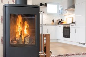 a fireplace in the middle of a kitchen at Penthouse Kapitänskajüte, App 25 Olpenitz in Olpenitz