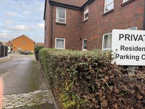 a sign in front of a brick building with a residential parking sign at 48 Harper Road Beckton Shared in East Ham