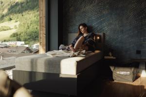 a woman sitting on a bed with a dog at PACHMAIR 1453 apart resort in Uderns