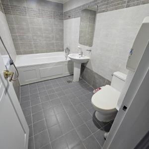 a bathroom with a toilet and a tub and a sink at 대전 유천 샌디스테이 