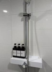 a bathroom with a shower with four bottles on a shelf at 대전 유천 샌디스테이 