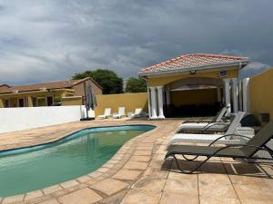 a swimming pool with lounge chairs next to a house at Ein Gedi Premier Weddings And Conferences in Kimberley