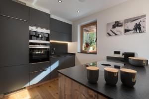 a kitchen with black cabinets and a black counter top at Chalet Florian in Kirchberg in Tirol +10 photos
