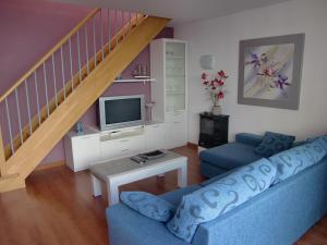 a living room with a blue couch and a staircase at Apartment Sun & Beach in Platja d'Aro in Platja d'Aro