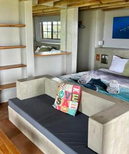 Cama grande en habitación con almohada en Mdumbi lodge, en Ngqeleni