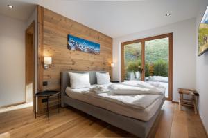 a bedroom with a large bed with a wooden wall at Chalet Florian in Kirchberg in Tirol