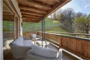a porch with wicker chairs and a table with a view at Chalet Florian in Kirchberg in Tirol