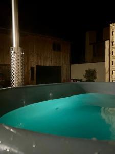 a large blue bath tub in a room with a television at Le Hameau des Bruyères in Cercié