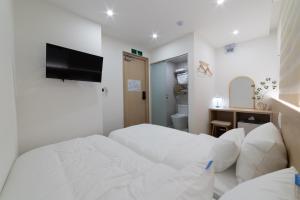 ソウルにあるHi Seoul Hostel Centralの白いベッドルーム(ベッド1台、テレビ付)