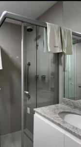 a bathroom with a glass shower and a sink at Studio Lumiere in Sao Paulo