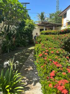 a man riding a bike in a garden with flowers at Escape-Cabins in Ko Lanta