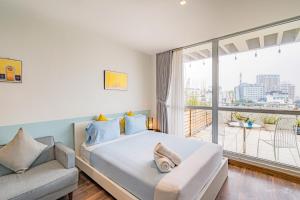 een slaapkamer met een bed, een bank en een balkon bij WECOZY HANOI - Railway Side, The Old Quarter in Hanoi