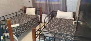 two twin beds in a room with a window at Vip charme in Fès