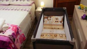 a baby crib in a room with two beds at Home in Garfagnana in Vagli di Sotto