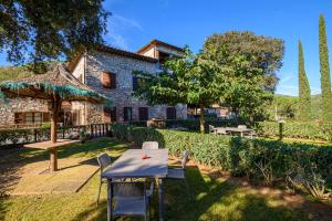 ein Tisch und Stühle vor einem Gebäude in der Unterkunft Il Castagno Toscana in Campiglia Marittima