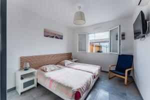 Un dormitorio con una cama y una silla azul. en Villa piscine entre lac et océan, en Cazaux 19 fotos más