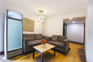 a living room with two couches and a table at FabHotel Crescent in Faridabad