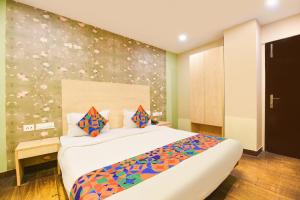 a bedroom with a bed and a wall with flowers at FabHotel Crescent in Faridabad