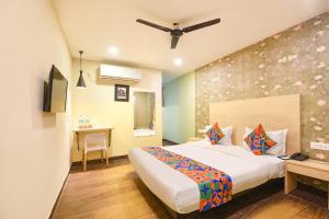 a hotel room with a bed and a desk at FabHotel Crescent in Faridabad +17 photos
