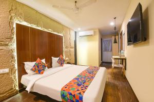 a bedroom with a bed and a television in a room at FabHotel Crescent in Faridabad