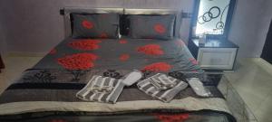 a bed with red flowers on it with shoes on it at VIP Charme Fès in Fez