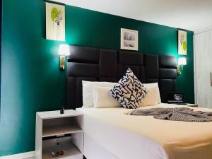 a bedroom with a large bed with a green wall at Solovina Guest House in Foso
