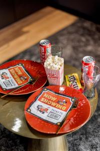 deux assiettes rouges avec du pop-corn et du soda sur une table dans l'établissement La cinemaRoom d'Auterive - Son Immersif Dolby et Atmos - Netflix, à Auterive 8 autres photos
