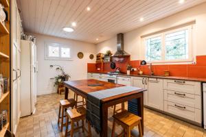 a large kitchen with a wooden table and chairs at Chambres d'hotes du Prieur in Léognan