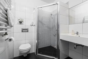 a bathroom with a shower and a toilet and a sink at Pałac nad Jeziorem in Chociwel